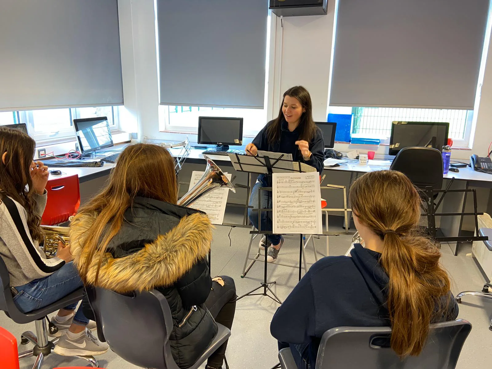A Fairey musician leading a sectional for young brass players